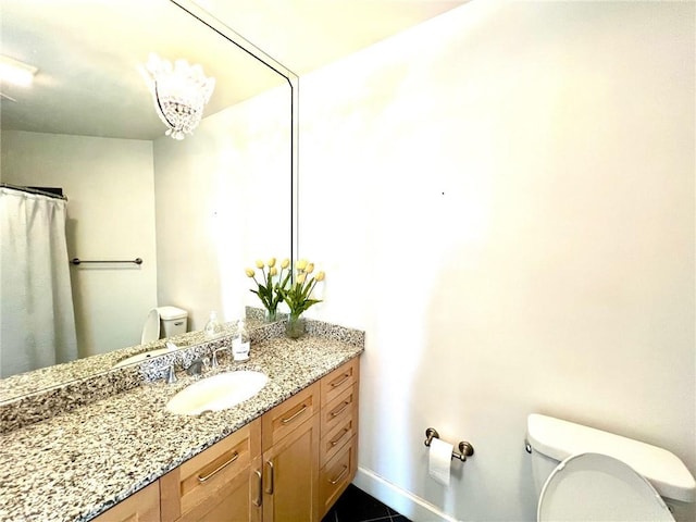 bathroom with vanity, toilet, and baseboards