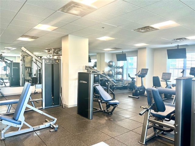 workout area with baseboards, visible vents, and a drop ceiling