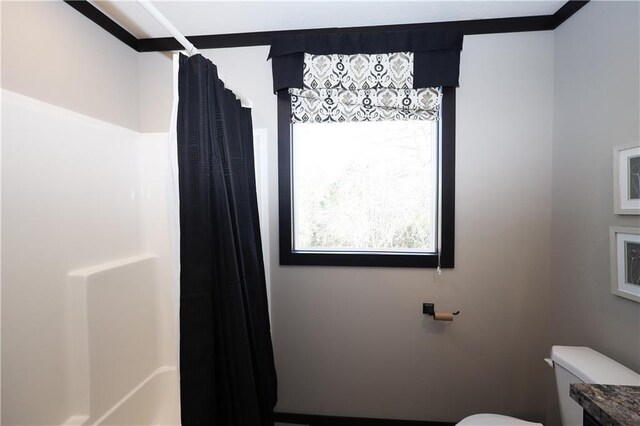 bathroom featuring curtained shower and toilet