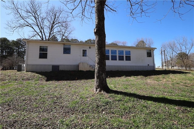 view of side of property with a yard and central AC unit