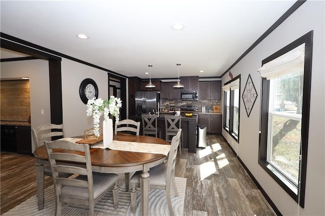 dining space with recessed lighting, crown molding, and wood finished floors