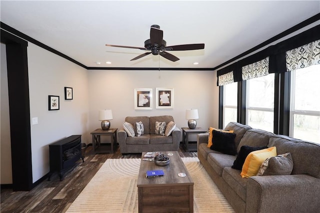 living area featuring dark wood-style floors, ceiling fan, a wood stove, crown molding, and recessed lighting