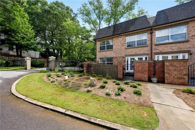 6980 Roswell Rd # A8, Atlanta, GA 30328 - view of front facade with a gate, a fenced front yard, brick siding, and roof with shingles