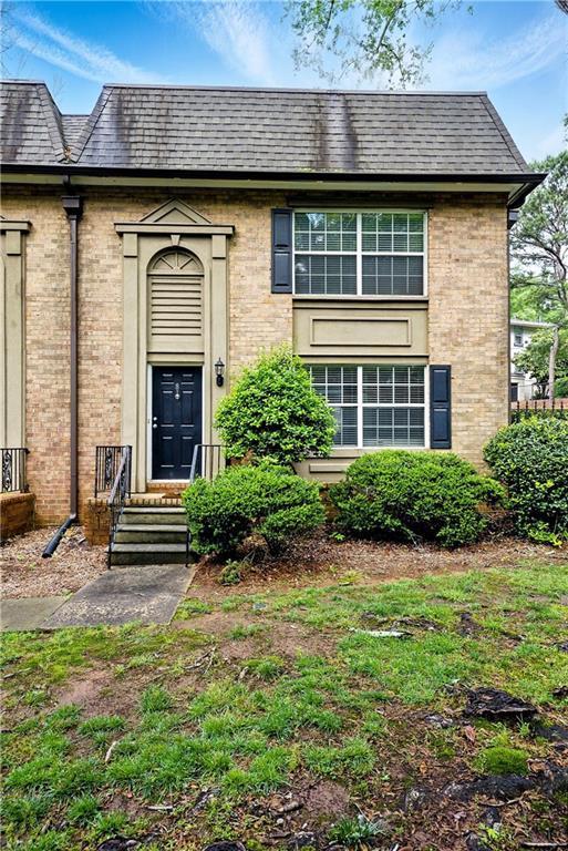 6980 Roswell Rd # A8, Atlanta, GA 30328 - doorway to property with brick siding and mansard roof