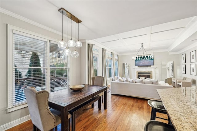 dining room with hardwood / wood-style flooring, ornamental molding, and coffered ceiling