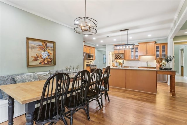 dining space with recessed lighting, a chandelier, light wood finished floors, and crown molding