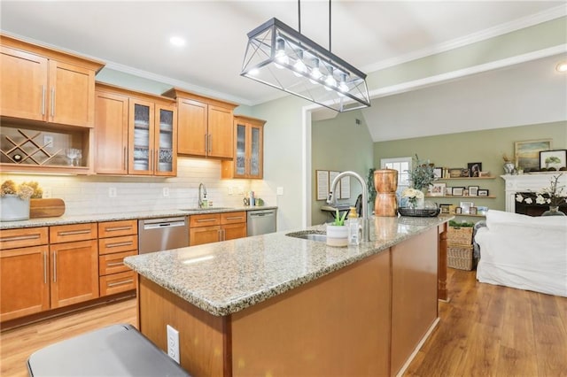 kitchen featuring a sink, open floor plan, stainless steel dishwasher, light wood-style floors, and crown molding