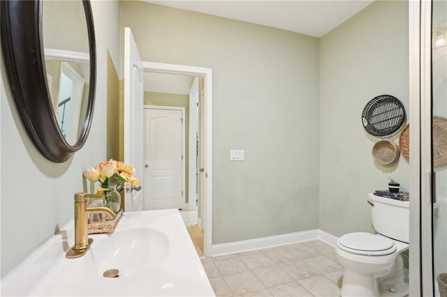 half bathroom featuring toilet, tile patterned floors, baseboards, and vanity
