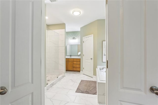 full bathroom with a stall shower, marble look tiles, and vanity