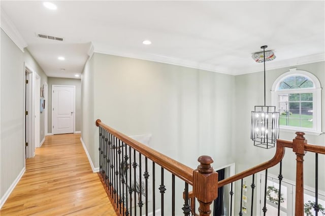 hall featuring a chandelier, an upstairs landing, light wood-style floors, ornamental molding, and recessed lighting