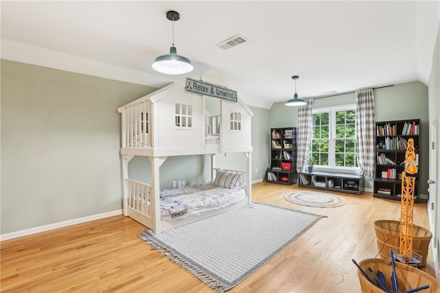 bedroom featuring wood finished floors, baseboards, and vaulted ceiling