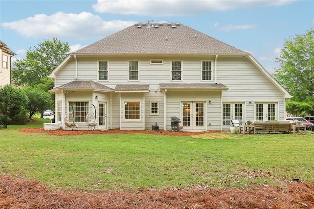rear view of house featuring french doors, a lawn, outdoor lounge area, and roof with shingles