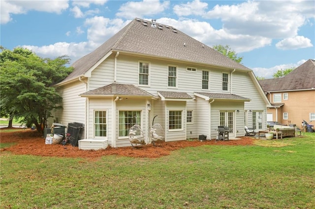 back of property featuring a shingled roof, french doors, a yard, and a patio
