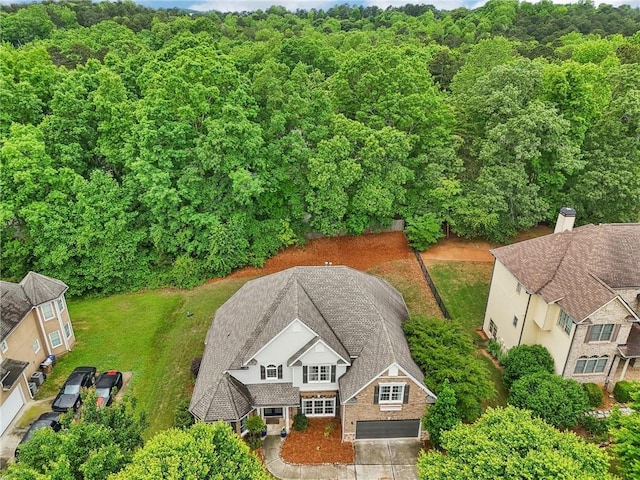 aerial view of property and surrounding area featuring a heavily wooded area