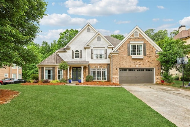 view of front of house with an attached garage, concrete driveway, a front yard, and brick siding