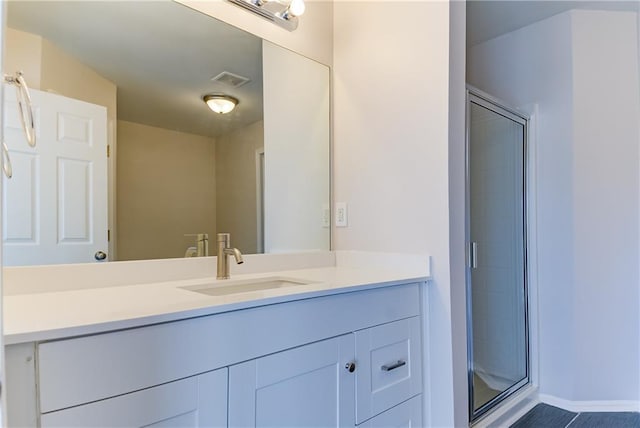 bathroom featuring tile patterned floors, vanity, and a shower with shower door