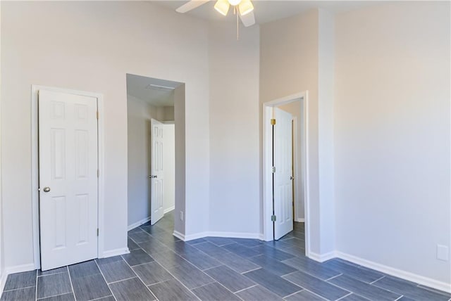 empty room featuring ceiling fan and a high ceiling