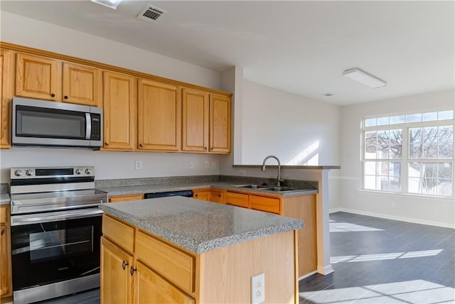 kitchen featuring light stone countertops, stainless steel appliances, sink, a center island, and dark hardwood / wood-style floors