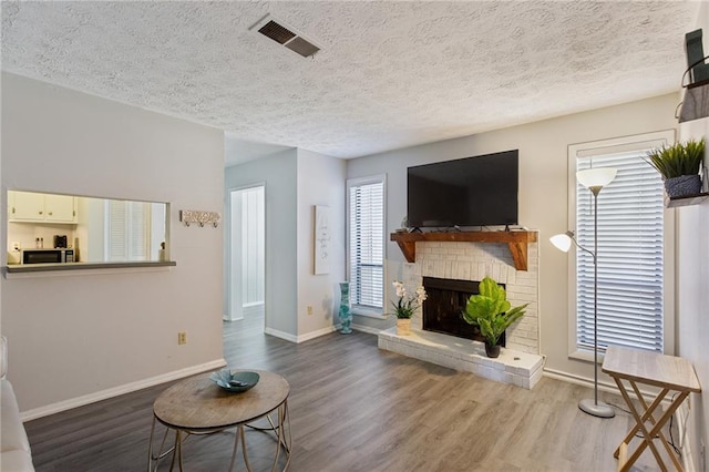 living room featuring hardwood / wood-style floors, a fireplace, and a textured ceiling