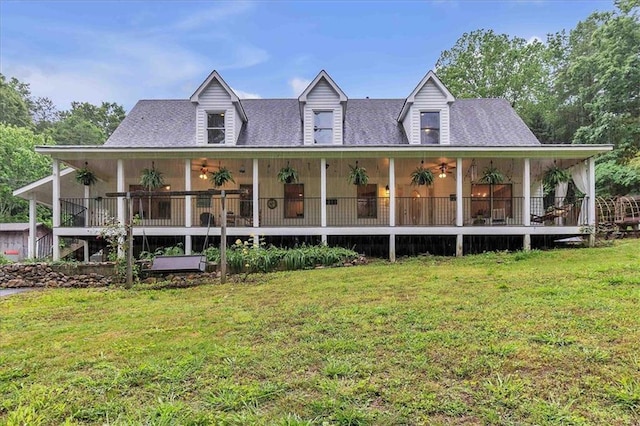back of property featuring a lawn, a ceiling fan, and a shingled roof