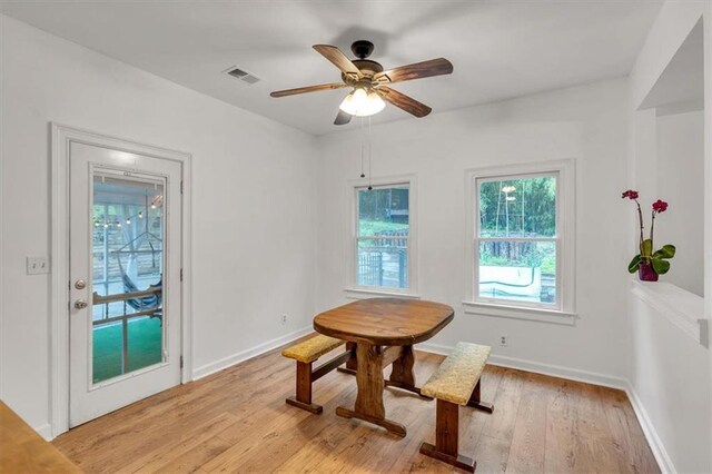 dining area with light wood finished floors, ceiling fan, and baseboards