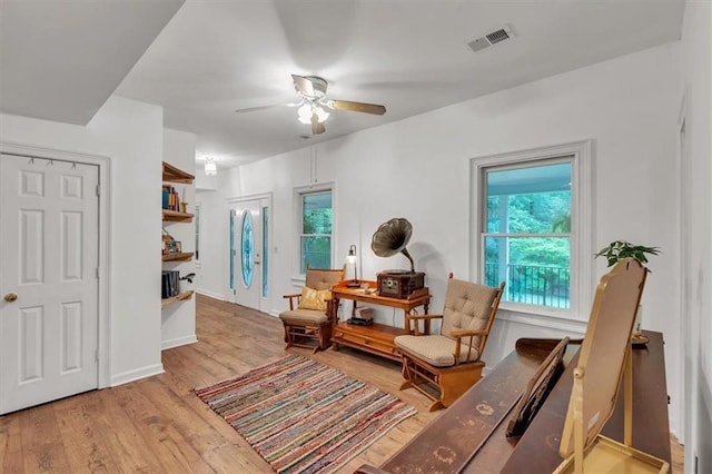 sitting room with a ceiling fan and wood finished floors