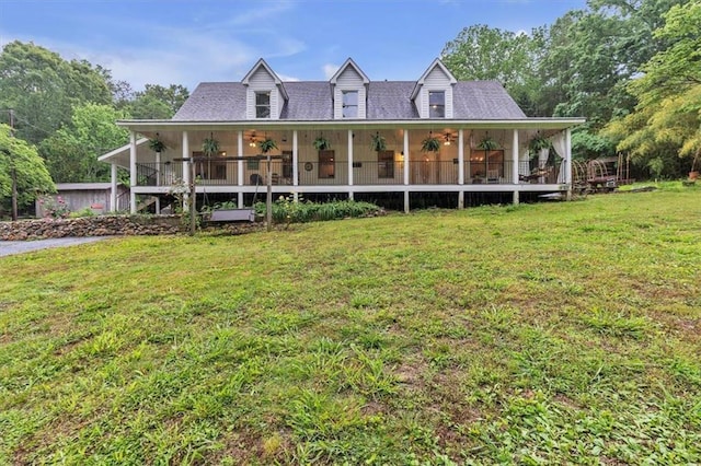 rear view of house featuring a yard and ceiling fan