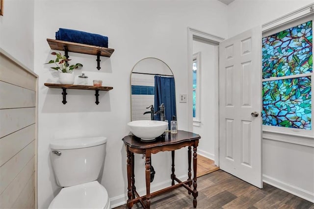 full bath with wood finished floors, toilet, a sink, and baseboards