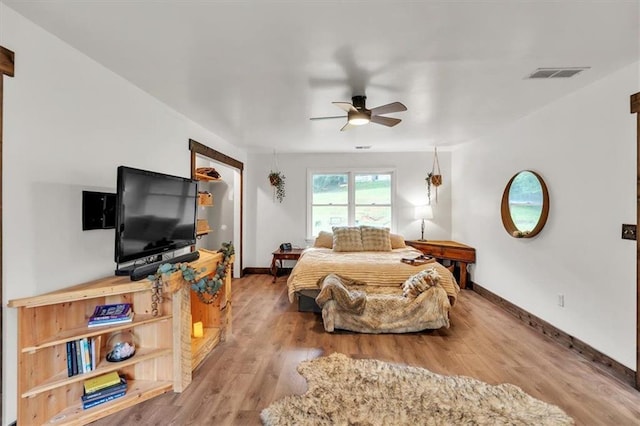 living room featuring a ceiling fan, baseboards, and wood finished floors