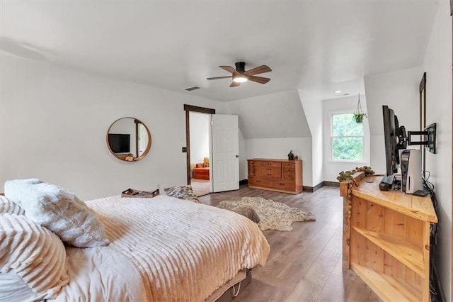 bedroom with hardwood / wood-style flooring, vaulted ceiling, a ceiling fan, and baseboards