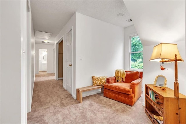 sitting room with light carpet and attic access