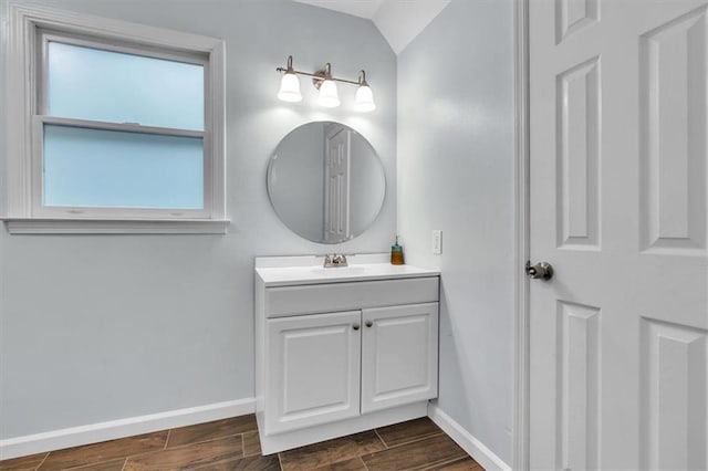 bathroom with baseboards, wood finish floors, and vanity