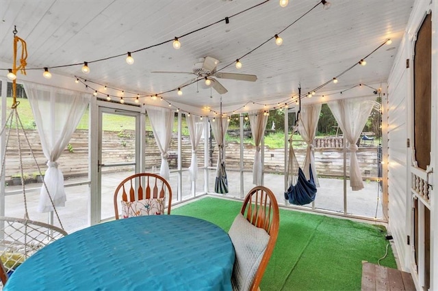 sunroom with a ceiling fan and outdoor dining space