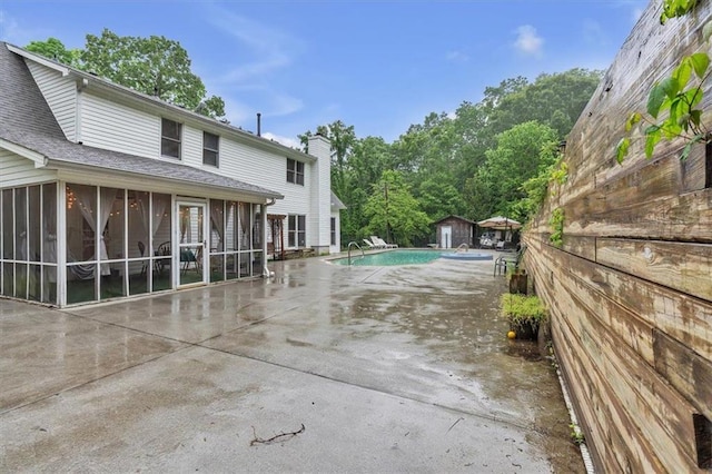 view of swimming pool with a sunroom and a patio area