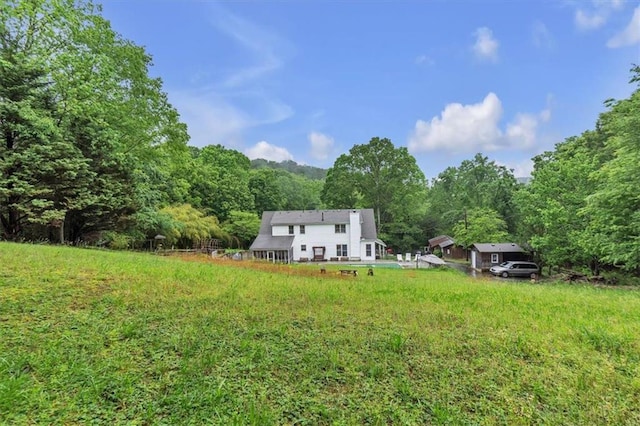 rear view of property featuring a wooded view