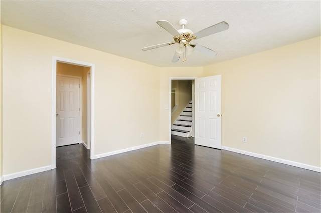 5867 Trent Walk Dr, Lithonia, GA 30038 - empty room with baseboards, dark wood-style floors, a ceiling fan, and stairs