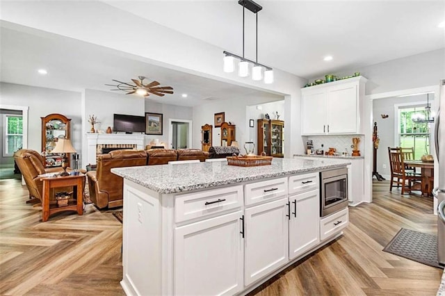 1505 Willis Rd, Barnesville, GA 30204 - kitchen featuring stainless steel microwave, plenty of natural light, decorative light fixtures, recessed lighting, and a center island
