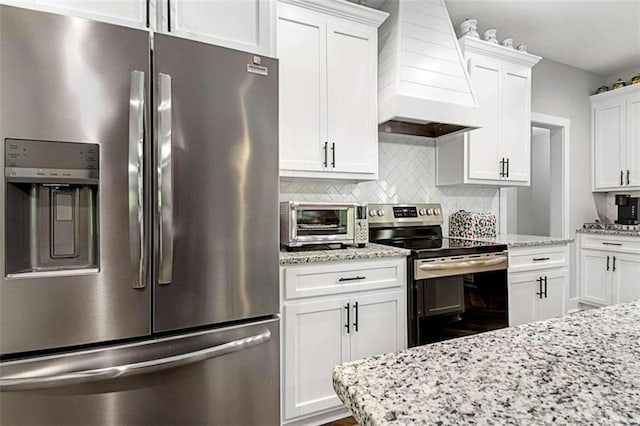 1505 Willis Rd, Barnesville, GA 30204 - kitchen featuring stainless steel appliances, custom range hood, white cabinets, backsplash, and light stone counters
