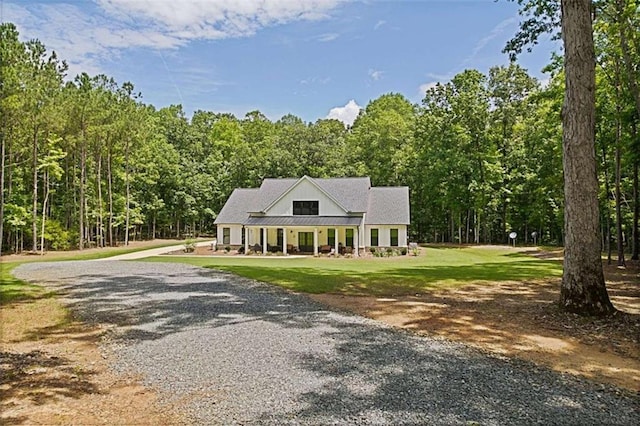 1505 Willis Rd, Barnesville, GA 30204 - modern farmhouse style home featuring gravel driveway, a front yard, a view of trees, and a metal roof