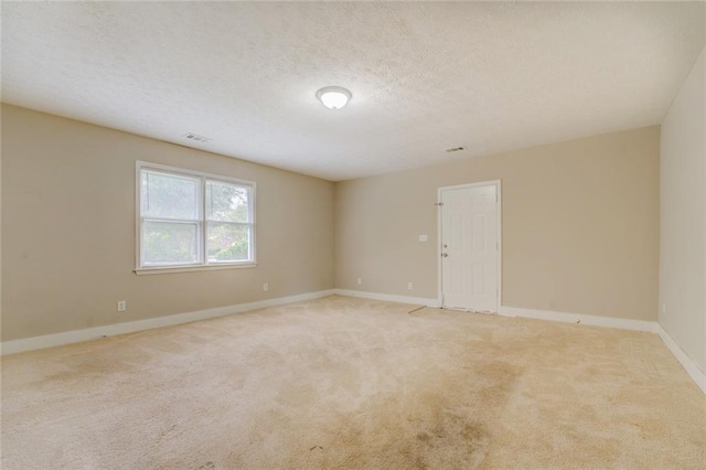 carpeted spare room featuring a textured ceiling