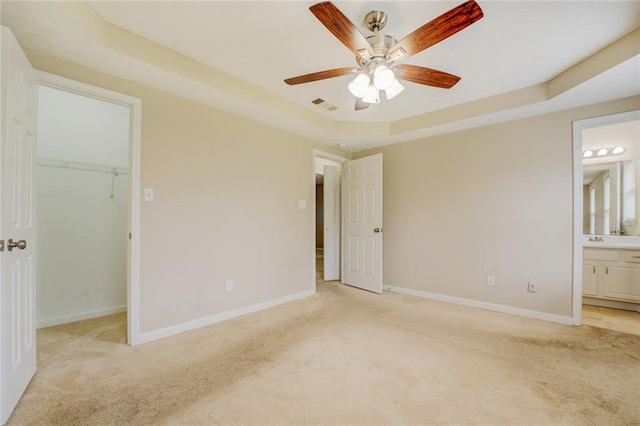 1187 Dixie Rd, Covington, GA 30014 - unfurnished bedroom with light carpet, a raised ceiling, a spacious closet, baseboards, and a sink