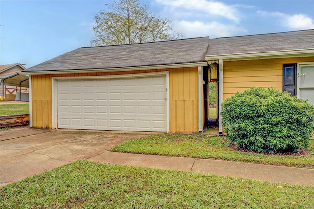 garage featuring a carport and a lawn