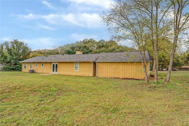 1187 Dixie Rd, Covington, GA 30014 - back of house with french doors, cooling unit, a lawn, and a chimney