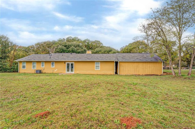 rear view of property featuring cooling unit and a yard