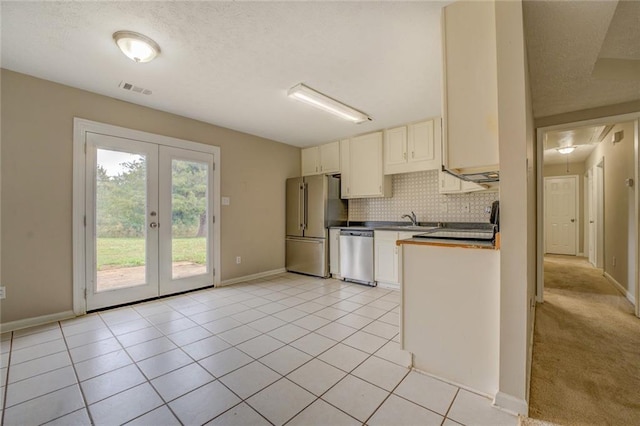 1187 Dixie Rd, Covington, GA 30014 - kitchen featuring appliances with stainless steel finishes, french doors, tasteful backsplash, a sink, and a textured ceiling