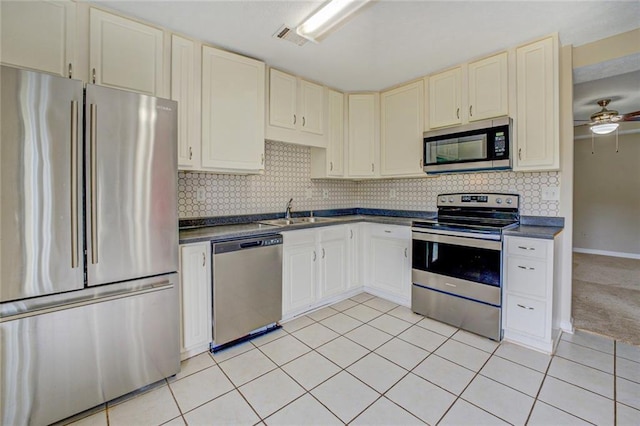 1187 Dixie Rd, Covington, GA 30014 - kitchen featuring stainless steel appliances, dark countertops, a sink, and decorative backsplash