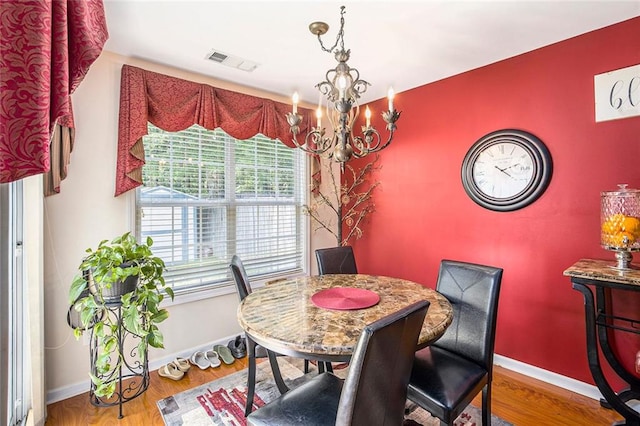 3198 Liberty Commons Dr, Kennesaw, GA 30144 - dining room featuring a chandelier, an accent wall, and wood finished floors