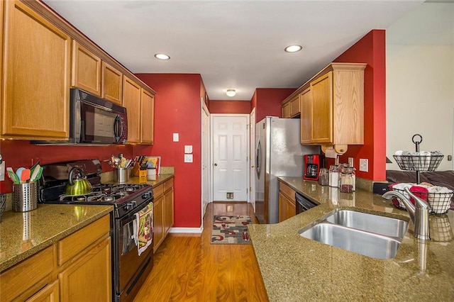 3198 Liberty Commons Dr, Kennesaw, GA 30144 - kitchen featuring black appliances, wood finished floors, brown cabinetry, dark stone countertops, and recessed lighting
