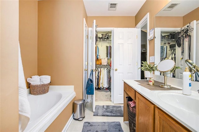 3198 Liberty Commons Dr, Kennesaw, GA 30144 - bathroom with a walk in closet, vanity, a bath, and tile patterned flooring