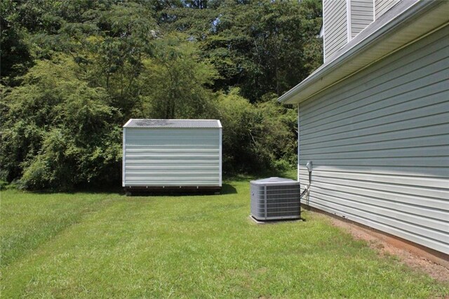 view of yard with a storage shed and central AC